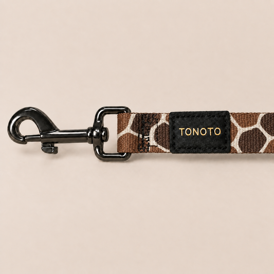 Close-up of giraffe pattern dog lead snap hook and TONOTO label