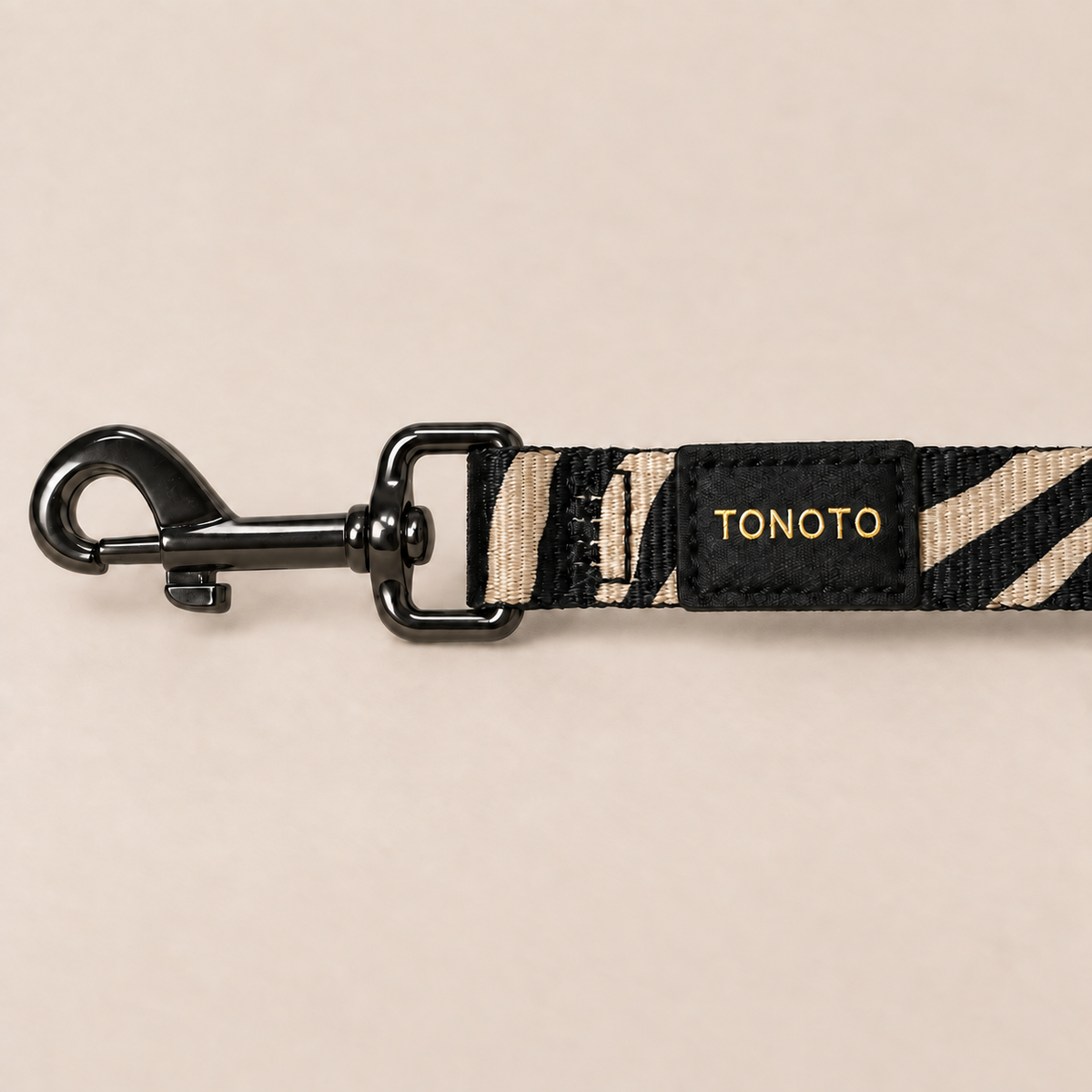 Close-up of zebra pattern dog lead snap hook and TONOTO label